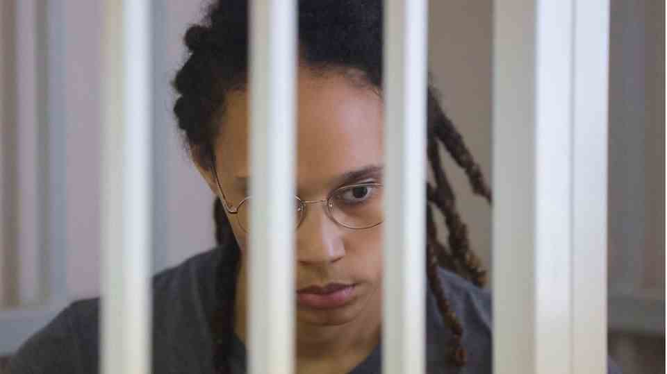 Brittney Griner is in a cage in a courtroom as she listens to the verdict
