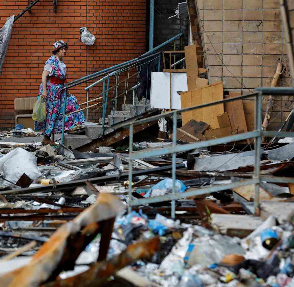 A woman walks outside an apartment building damaged in the course of Ukraine-Russia conflict in the southern port city of Mariupol, Ukraine August 21, 2022. REUTERS/Alexander Ermochenko TPX IMAGES OF THE DAY