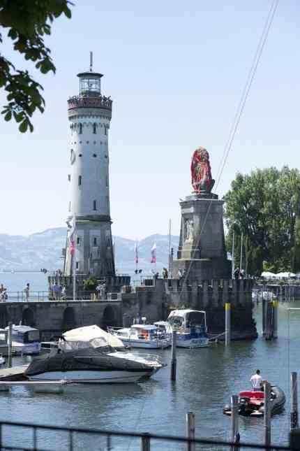 Art event: The Lindau harbor entrance with lighthouse and lion.  The latter is during the Biennale "In situ Paradise" surrounded by a red net.