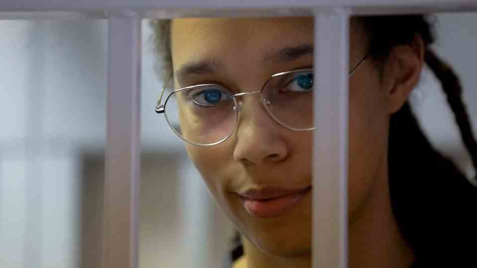 Brittney Griner stands in a cage in a courtroom before a hearing in Khimki