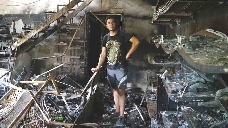 Alexander Prikhodko stands in his bombed-out textile and grocery store in Mykolaiv
