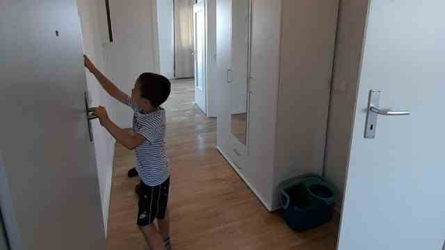 War in the Ukraine: Andrii tries out the door opener in the hallway of the new apartment in Halle an der Saale.