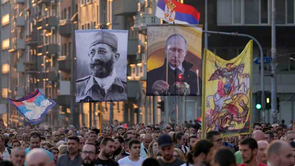 People show pictures of Russian President Putin and Mihailovic during a protest