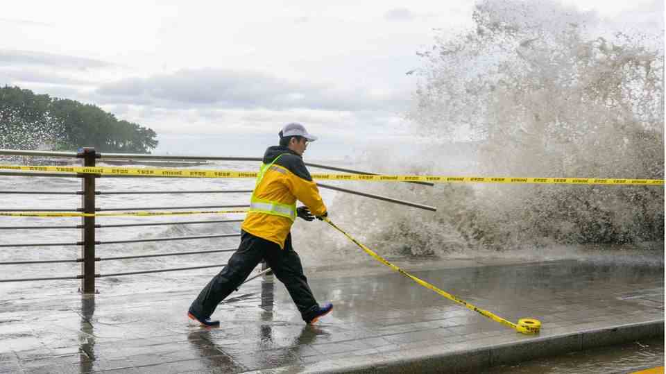 Busan, South Korea.  Typhoon Hinnamnor swept over the port city and left damage - for example on this railing.  A worker secures the dangerous spot with a barrier tape.
