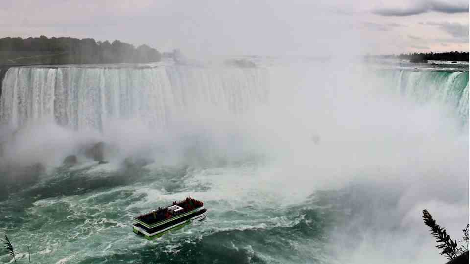 This is how many know Niagara Falls: the large, U-shaped waterfall that rushes down.  In front is a boat.