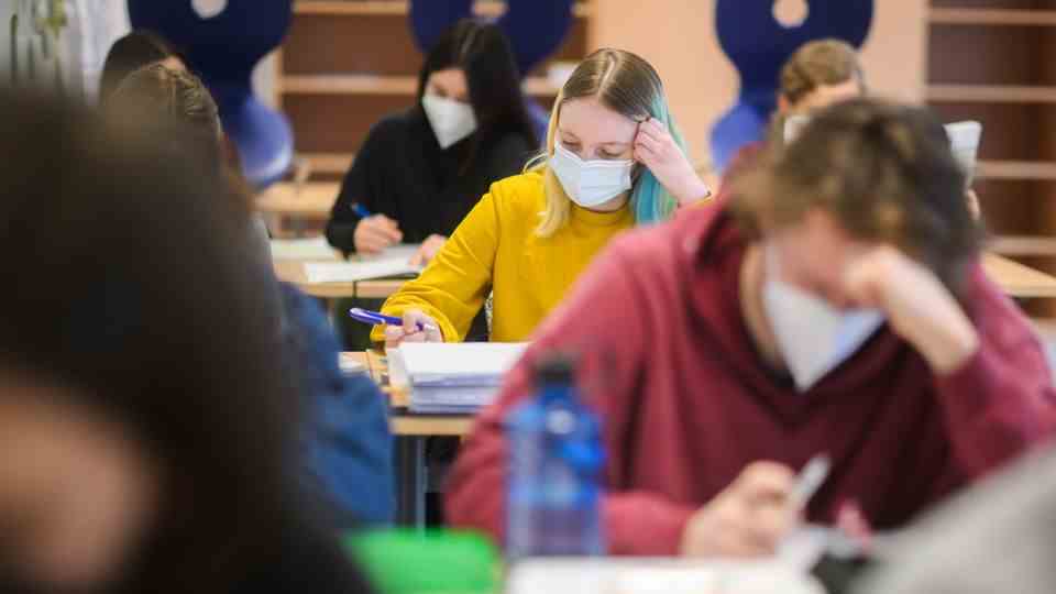 Pupils sit in class with masks and do schoolwork