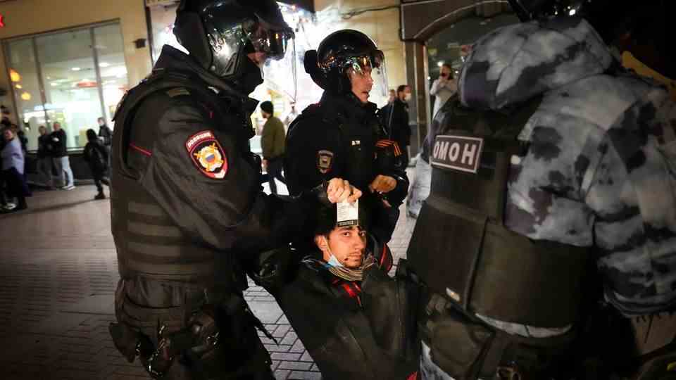 Police officers carry away a protester during a demonstration against mobilization
