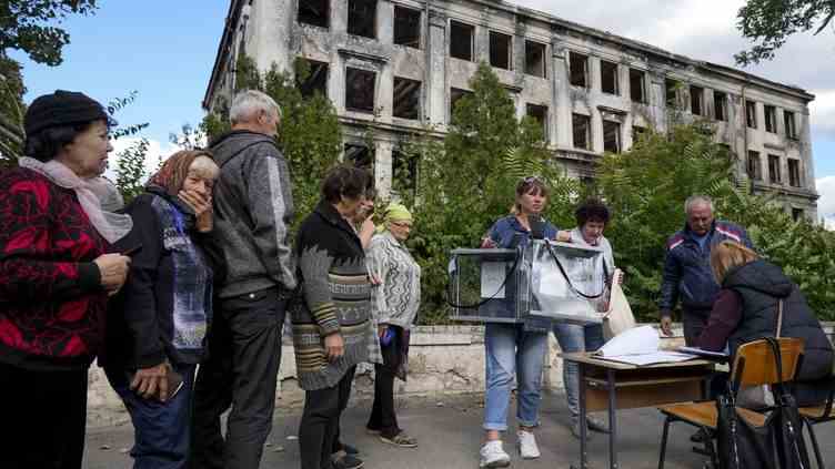 Plusieurs personnes votent au cours de l'un des référendums d'annexion organisés par la Russie, à Donetsk (Ukraine), le 25 septembre 2022. (ANADOLU AGENCY / AFP)