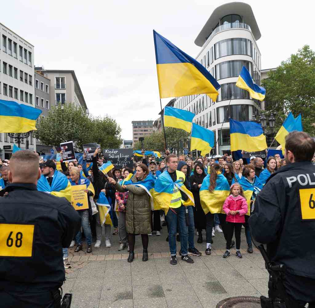 Demonstranten in Frankfurt schwenken Fahnen in den ukrainischen Nationalfarben