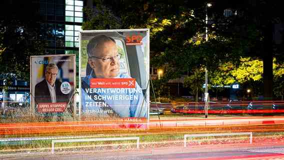 Election posters show Bernd Althusmann (CDU, l) and Stephan Weil (SPD, r) in the early morning while cars are driving along a main street.  © dpa-Bildfunk Photo: Moritz Frankenberg/dpa