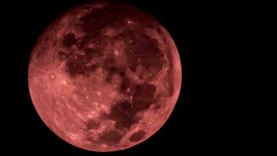 The moon glows reddish as "blood moon" over Rio de Janeiro