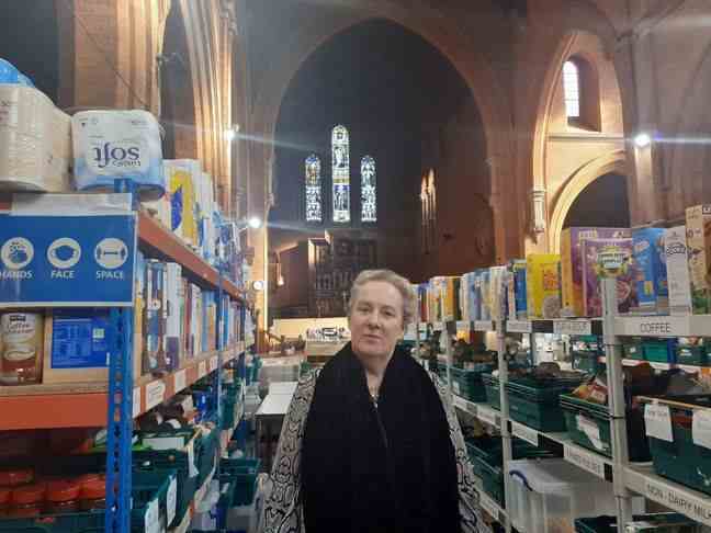 Alison, Foodbank board member, in front of the stocks at St Margaret's Church