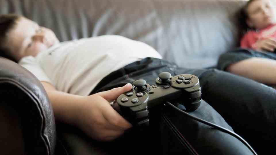 Boy sleeping on the sofa with a playstation controller in his hand