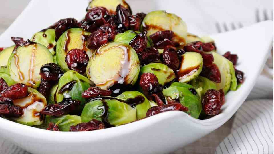 Brussels sprouts with cranberry sauce in a white bowl