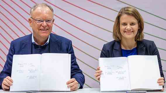Stephan Weil (SPD) and Julia Willie Hamburg (Bündnis 90/Die Grünen) show the coalition agreement between the SPD and the Greens in Lower Saxony after they have signed it.  © picture alliance/dpa Photo: Moritz Frankenberg