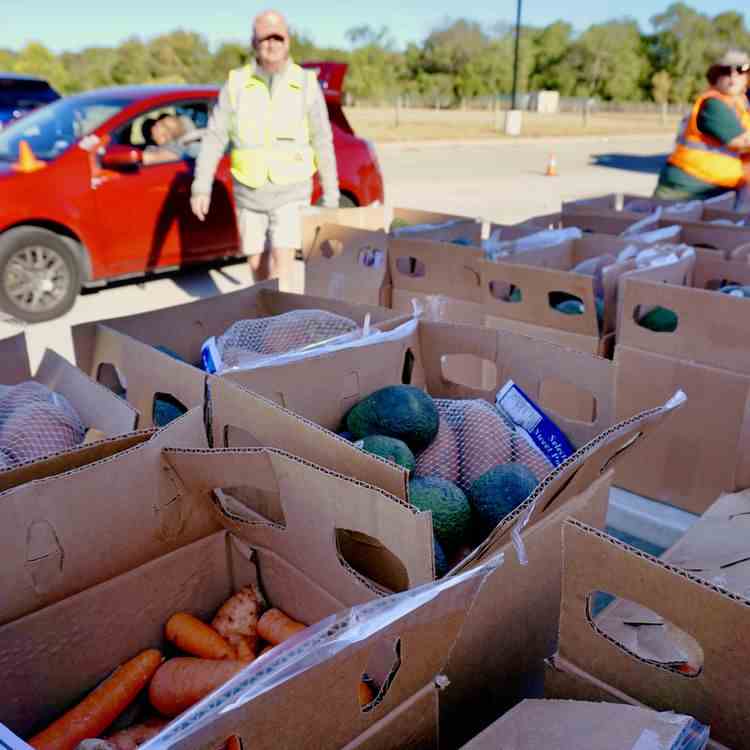 Des bénévoles de la Banque alimentaire du centre du Texas chargent des colis dans une voiture, le 25 octobre 2022, lors d'une distribution à Austin. (MARIE-VIOLETTE BERNARD / FRANCEINFO)