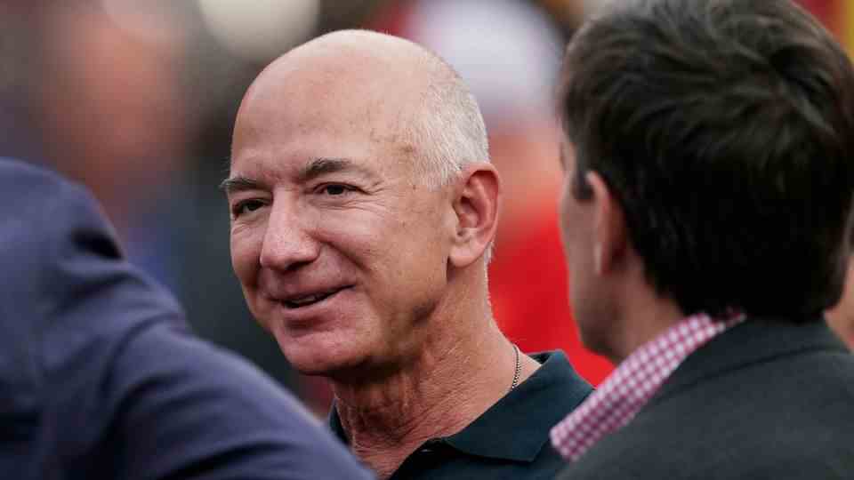 Jeff Bezos, a bald man, smiles