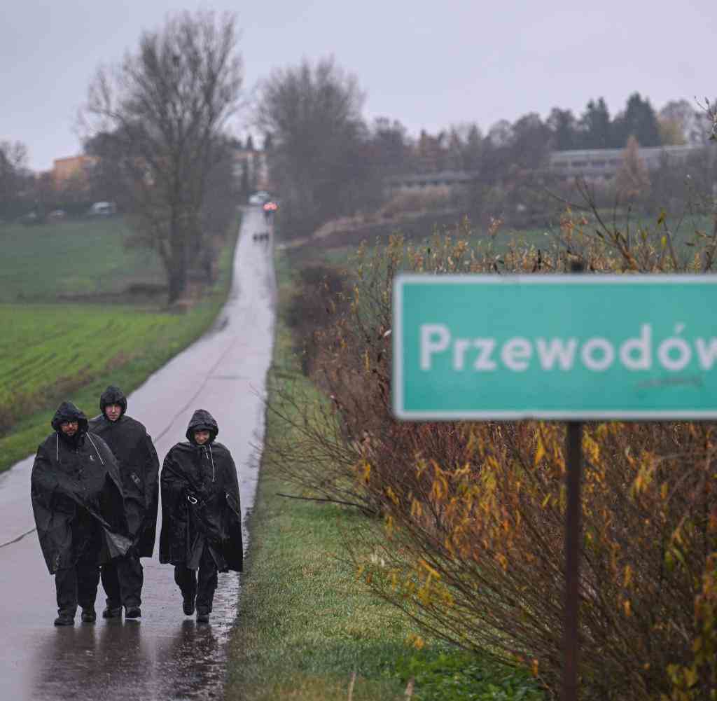 Polizisten in Regenmänteln ermitteln in der Stadt Przewodow in Polen