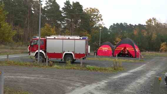 Firefighters are standing with tents in a parking lot.  © TeleNewsNetwork 