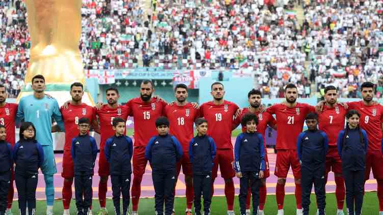 Les joueurs de l'équipe d'Iran restent silencieux pendant l'hymne national de leur pays avant leur entrée en lice à la Coupe du monde, contre l'Angleterre, le 21 novembre 2022 à Doha (Qatar). (FADEL SENNA / AFP)