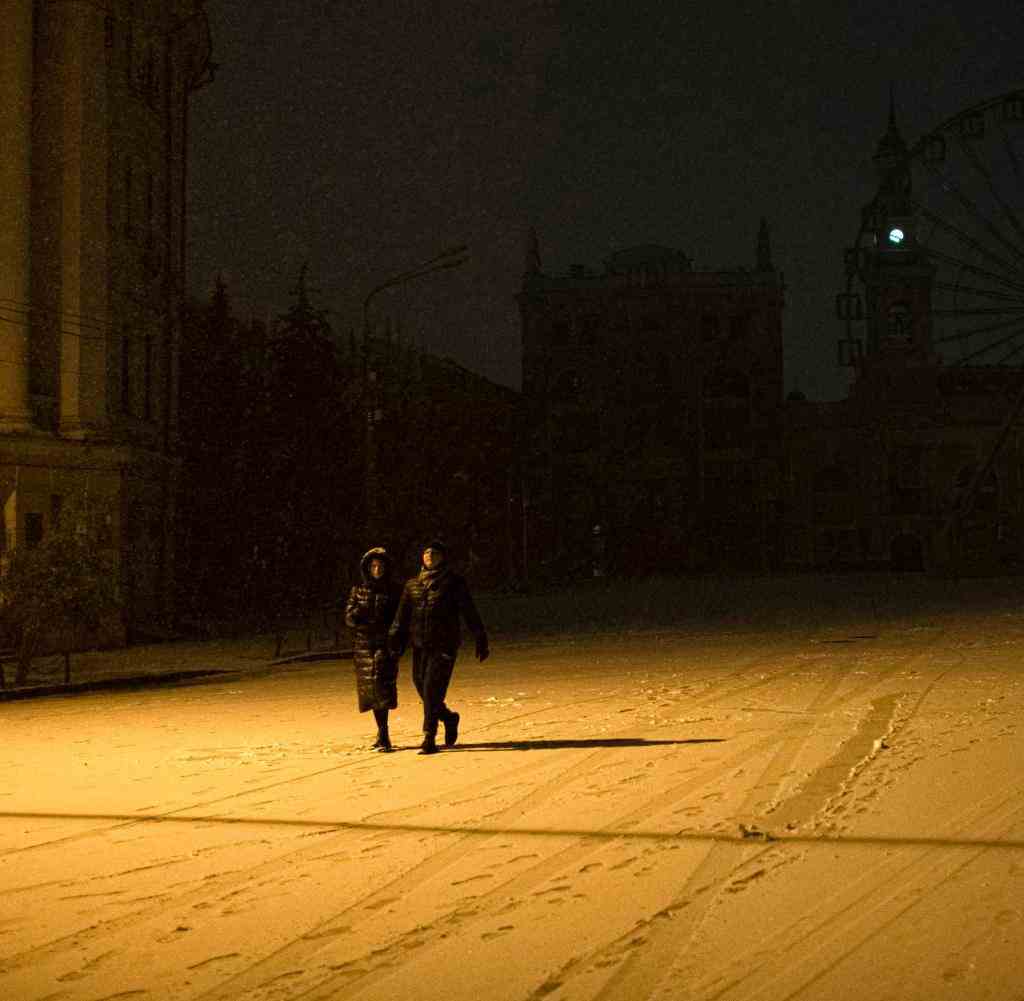 Menschen spazieren durch den Schnee im Stadtzentrum. Nach Angaben des Kiewer Bürgermeisters Klitschko sind eineinhalb Millionen Einwohner in Kiew ohne Strom