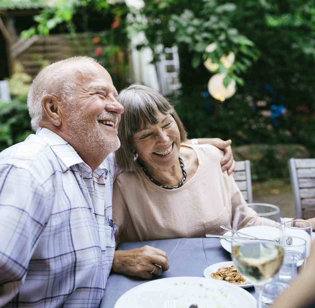 Elderly Couple Enjoying Outdoor Meal With Family