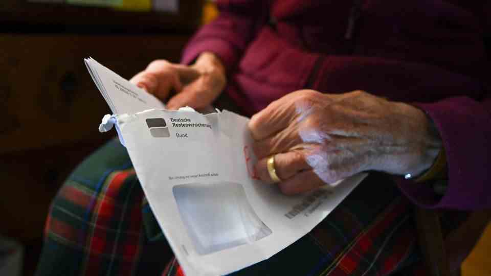 A pensioner opens a letter from the German pension insurance