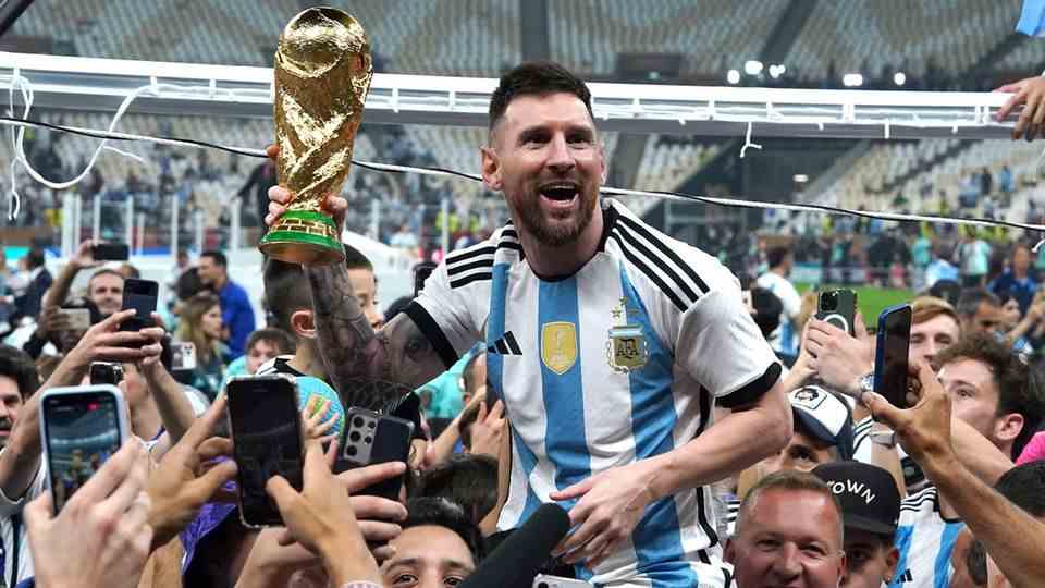 Lionel Messi celebrates with the World Cup trophy