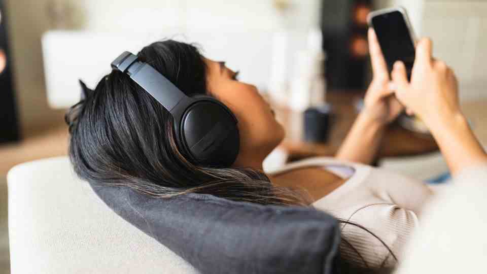 Woman sitting on the sofa with headphones