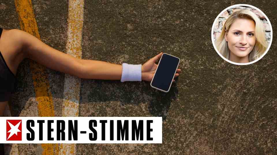 A smartphone in the hand of a woman lying on the ground