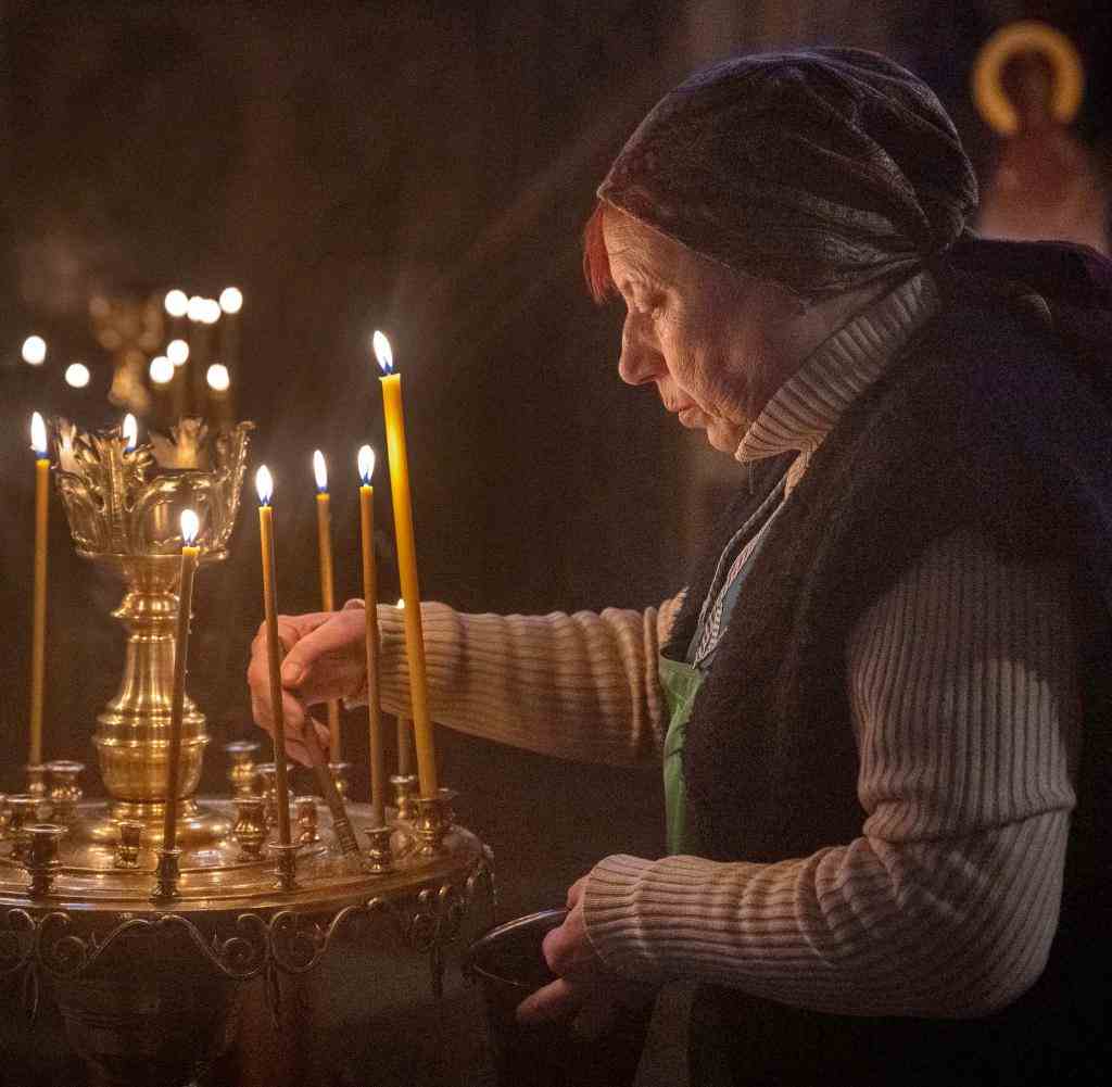 Eine Frau zündet Kerzen in der St.-Andreas-Kirche in Kiew an