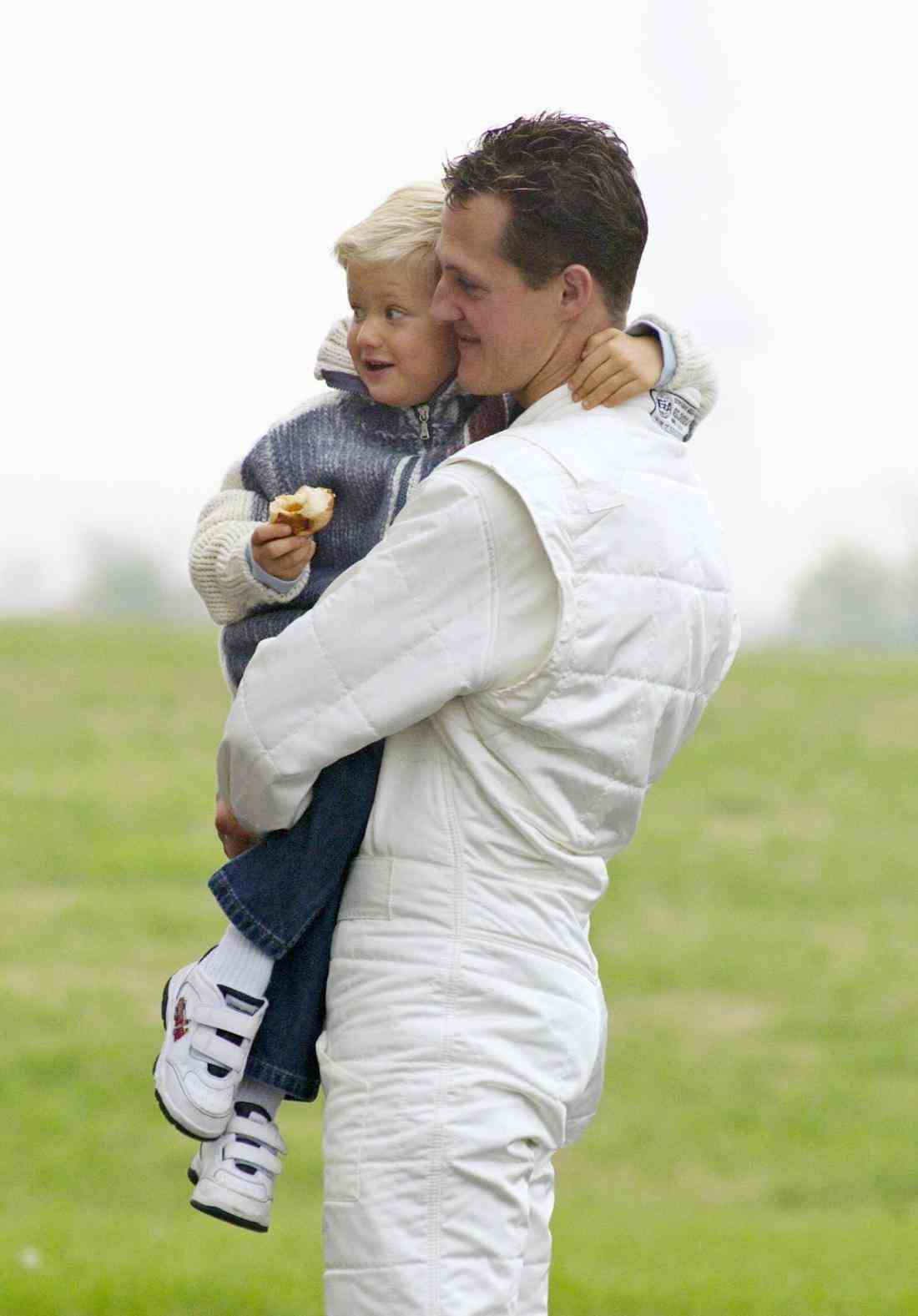 Michael Schumacher holds his son Mick in his arms.