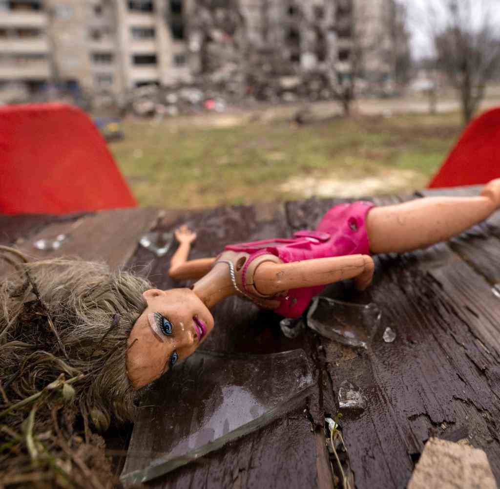 Eine Puppe liegt auf zerbrochenem Glas im ukrainischen Charkiw