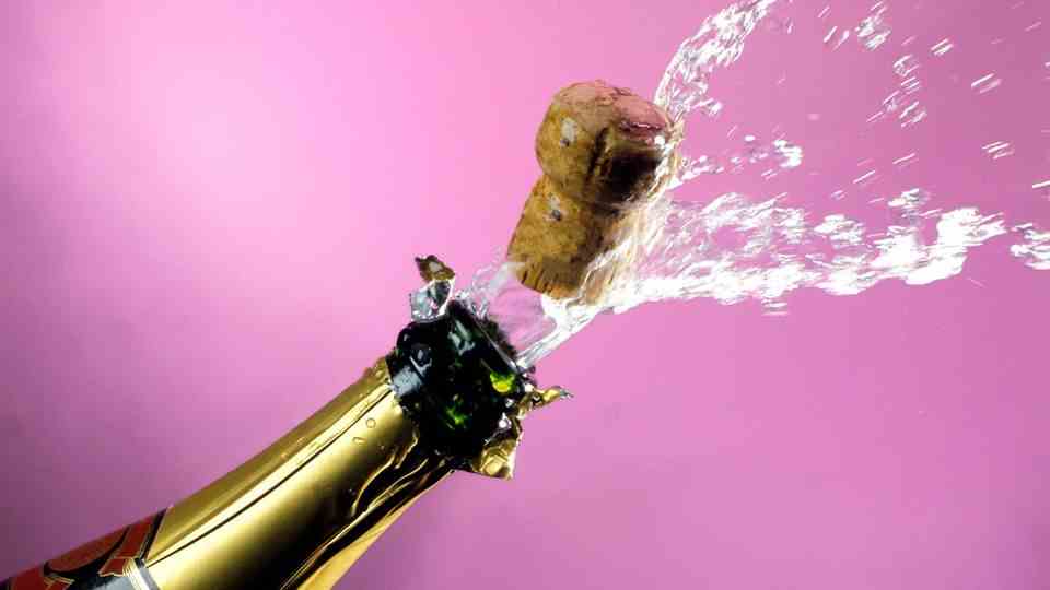 A cork flies out of the champagne bottle