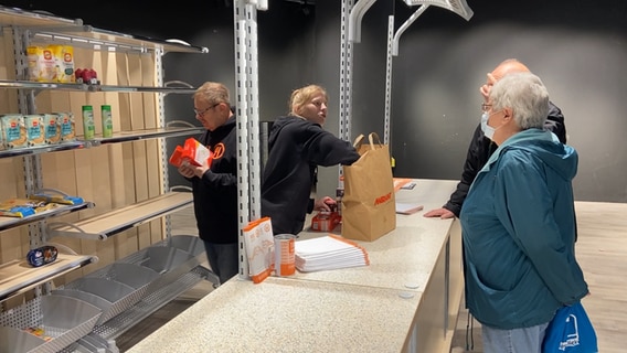 An employee of the Hamburger Tafel accepts donations.  © NDR Photo: Anna Rüter