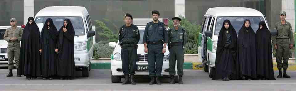 Iranian moral police officers in Iran's capital Tehran pose in front of cars