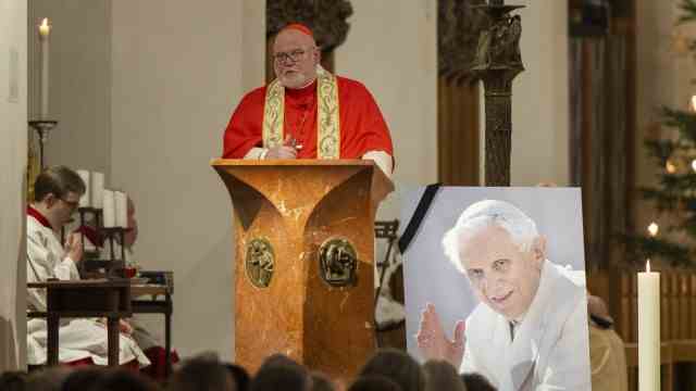 On the death of Pope Benedict XVI: Archbishop Reinhard Cardinal Marx speaks next to a photo of the late Pope Emeritus Benedict XVI on Saturday in Munich's Liebfrauendom during the New Year's Eve mass.  The Pope Emeritus died in the Vatican on December 31, 2022 at the age of 95.