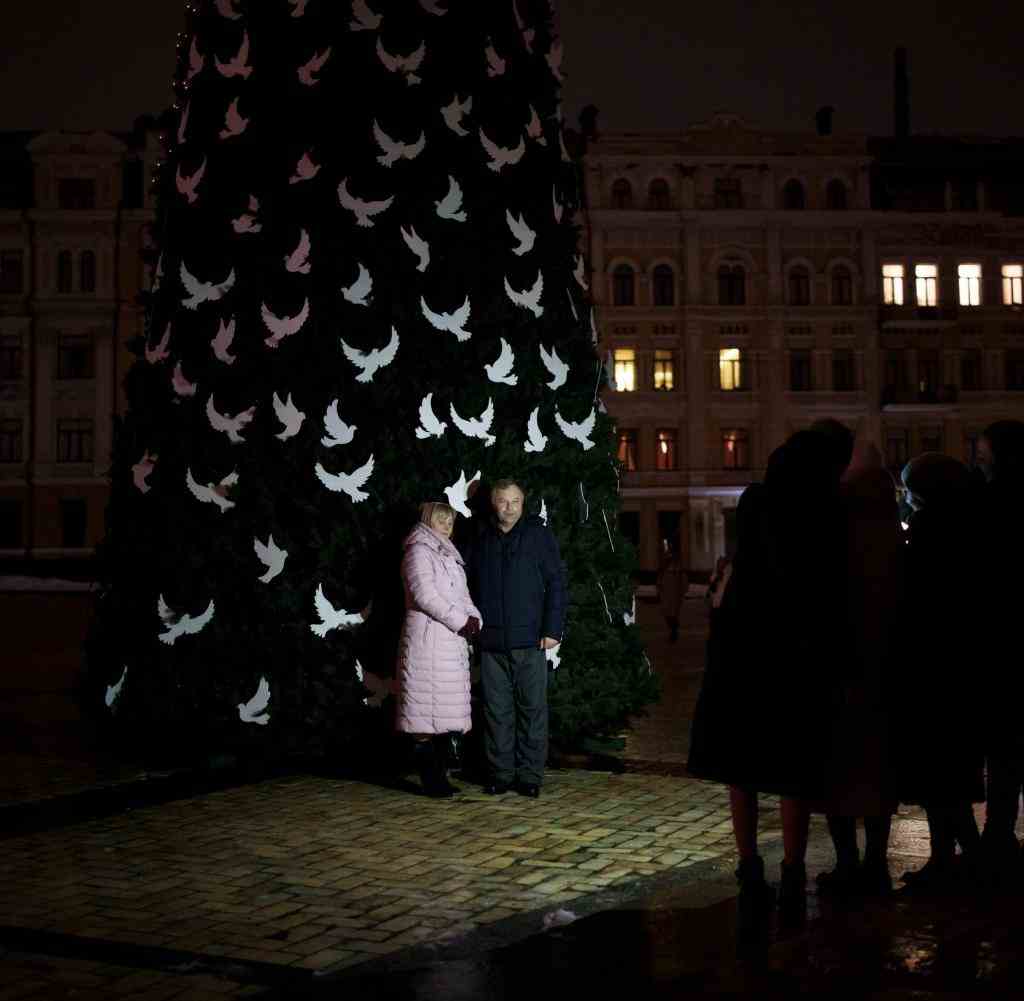 Ein Paar vor einem Weihnachtsbaum in Kiew. Durch russische Angriffe fällt weiterhin oft der Strom aus