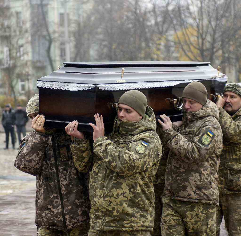 Ukrainische Soldaten tragen einen getöteten Kameraden zu Grabe