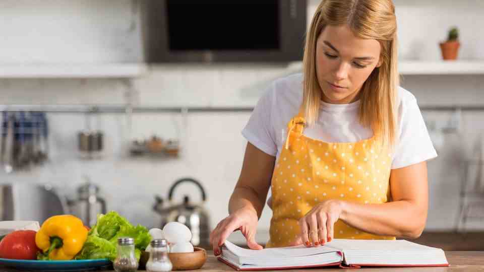 A woman reads a cookbook