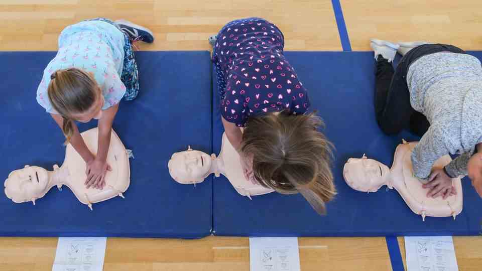 Children practice cardiopulmonary massage on mannequins