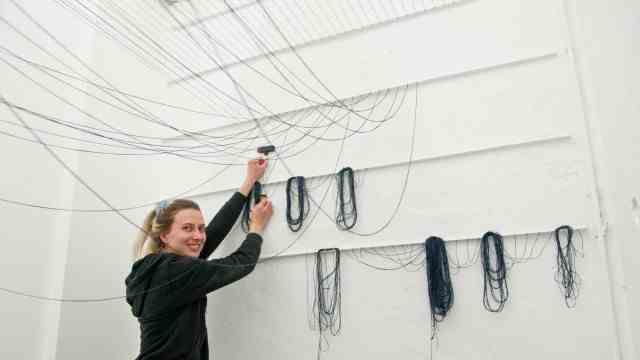 Vernissage on Friday: The young artists attached five rails to the wall for their room installation.  Jana Drexel attaches thin dark threads to it, which then have to be tightened.