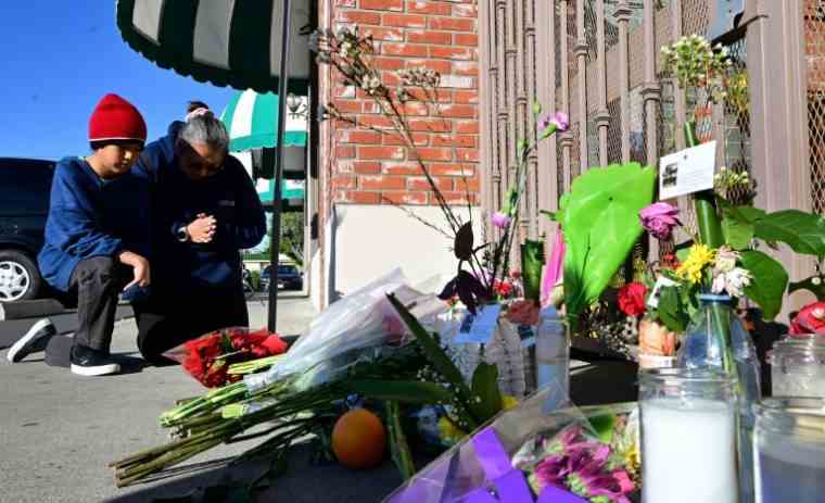 A woman and child pray in front of the memorial to the victims of the Star Dance Studio in Monterey Park on January 23, 2023 in California (AFP / Frederic J. BROWN)