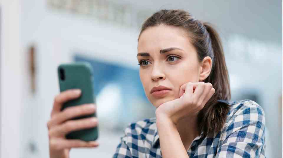 Worried woman sits in front of her iPhone