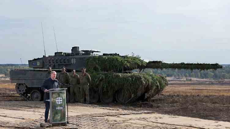German Chancellor Olaf Scholz speaks near a Leopard 2 tank, in Ostenholz (Germany), on October 17, 2022, during his visit to a field of the German army, the Bundeswehr.  (RONNY HARTMANN / AFP)