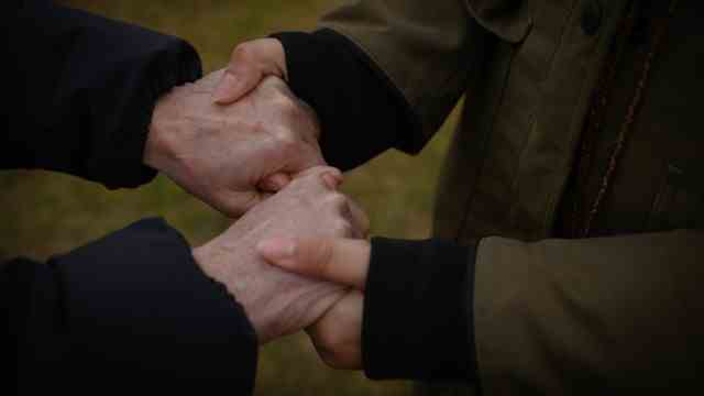Holocaust Remembrance Day in Auschwitz-Birkenau: hand in hand: the participants are close at the commemoration event.