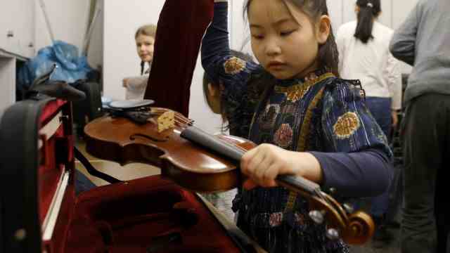 "youth makes music" at the music school in Freising: Eight-year-old Elinda unpacks her violin in the recital room.