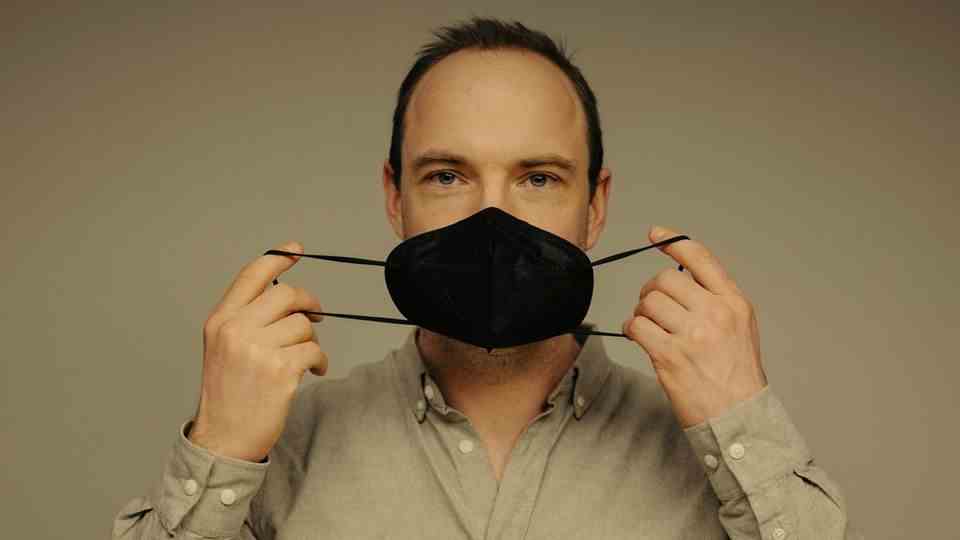 star knowledge editor Martin Schlak holds a mouth and nose protector in front of his face