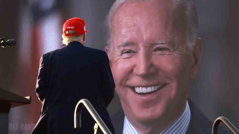 Donald Trump looks at a video screen of Joe Biden's face at a campaign event in November 2022