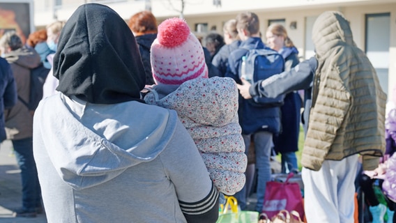 Refugees from Ukraine stand with their luggage in front of the buildings of a refugee home (symbolic image).  © dpa Photo: Henning Kaiser